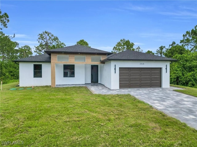 1018 Calvin Ave, Lehigh Acres, FL 33972 - prairie-style house with an attached garage, stucco siding, and a front yard