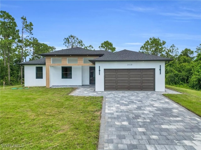 1018 Calvin Ave, Lehigh Acres, FL 33972 - prairie-style home with stucco siding, an attached garage, a front lawn, and decorative driveway