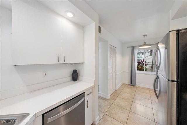 2810 Citrus Lake Dr Unit U101, Naples, FL 34109 - kitchen featuring stainless steel appliances, white cabinets, light countertops, light tile patterned floors, and hanging light fixtures