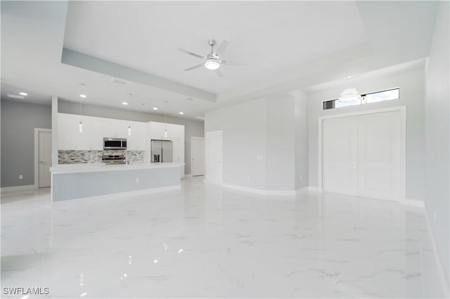 4002 22nd St SW, Lehigh Acres, FL 33976 - unfurnished living room with a ceiling fan, recessed lighting, and a tray ceiling