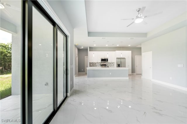 4002 22nd St SW, Lehigh Acres, FL 33976 - unfurnished living room with a ceiling fan, light marble finish flooring, and a raised ceiling