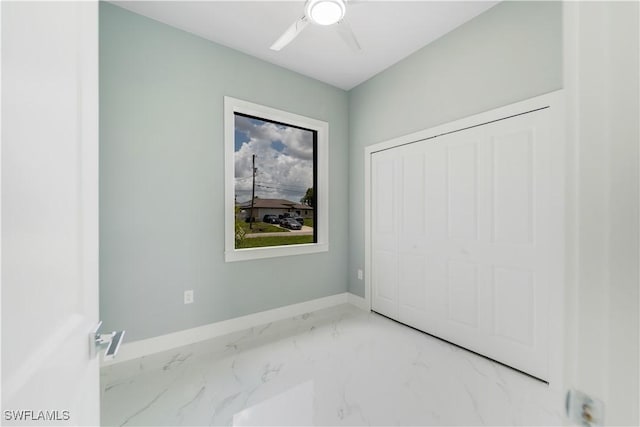 4002 22nd St SW, Lehigh Acres, FL 33976 - unfurnished bedroom featuring marble finish floors, a closet, and a ceiling fan