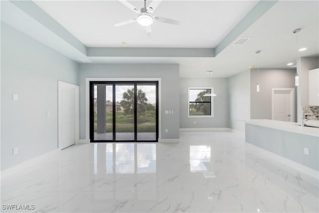 4002 22nd St SW, Lehigh Acres, FL 33976 - spare room featuring light marble finish floors, a ceiling fan, and a raised ceiling
