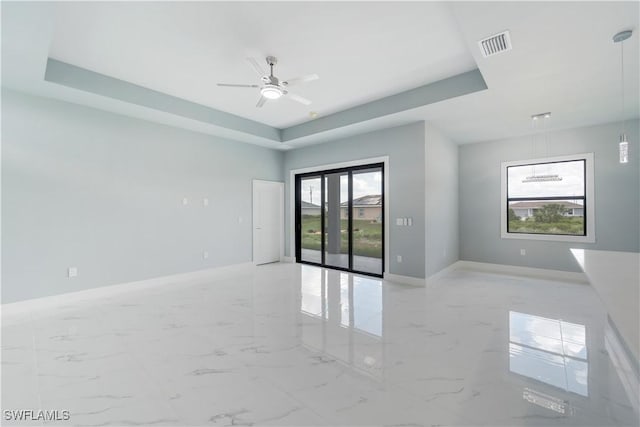 4002 22nd St SW, Lehigh Acres, FL 33976 - empty room featuring a ceiling fan, light marble finish flooring, and a tray ceiling