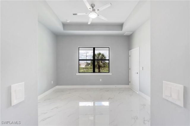 4002 22nd St SW, Lehigh Acres, FL 33976 - unfurnished room with a raised ceiling, marble finish flooring, and a ceiling fan