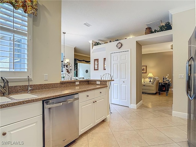 2050 Rio Nuevo Dr, North Fort Myers, FL 33917 - kitchen featuring stainless steel dishwasher, light tile patterned floors, white cabinetry, ornamental molding, and a peninsula