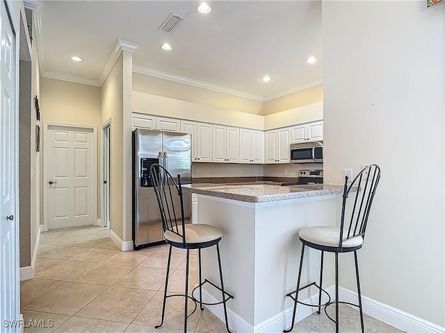 2050 Rio Nuevo Dr, North Fort Myers, FL 33917 - kitchen featuring appliances with stainless steel finishes, crown molding, a breakfast bar, a peninsula, and white cabinets