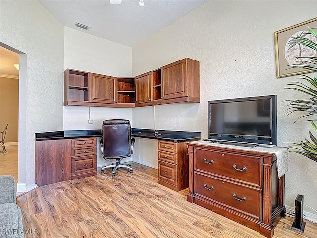 2050 Rio Nuevo Dr, North Fort Myers, FL 33917 - office space with built in desk, light wood-style floors, a textured wall, and vaulted ceiling