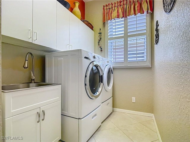 2050 Rio Nuevo Dr, North Fort Myers, FL 33917 - washroom featuring washer and clothes dryer, a textured wall, cabinet space, and light tile patterned floors