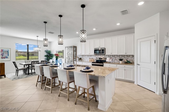 3470 Nombella Ct, Fort Myers, FL 33905 - kitchen featuring appliances with stainless steel finishes, decorative backsplash, light tile patterned floors, white cabinetry, and recessed lighting