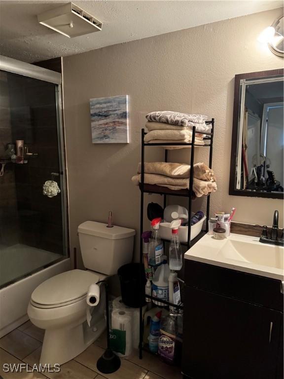 5307 Summerlin Rd Unit 704, Fort Myers, FL 33919 - full bathroom featuring tile patterned flooring, vanity, a textured ceiling, and bath / shower combo with glass door