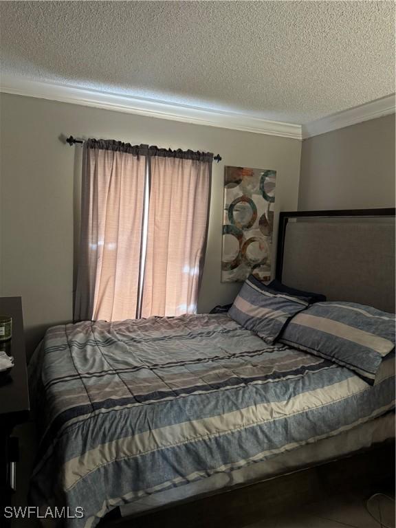 5307 Summerlin Rd Unit 704, Fort Myers, FL 33919 - bedroom featuring crown molding and a textured ceiling
