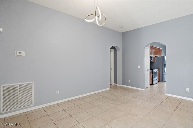 8169 Silver Birch Way, Lehigh Acres, FL 33971 - empty room with arched walkways, light tile patterned floors, and a chandelier