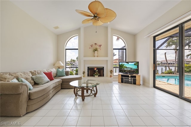 1167 SW 57th St, Cape Coral, FL 33914 - living room featuring vaulted ceiling, plenty of natural light, ceiling fan, light tile patterned floors, and a fireplace with raised hearth