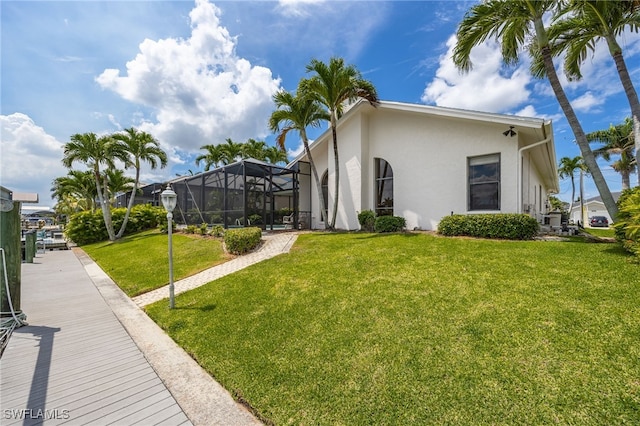 1167 SW 57th St, Cape Coral, FL 33914 - view of home's exterior with stucco siding, a yard, and glass enclosure