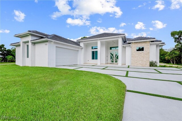 192 Herron Rd, North Fort Myers, FL 33903 - prairie-style house featuring stucco siding, a front yard, a garage, and concrete driveway