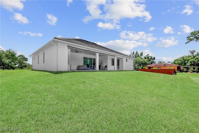 192 Herron Rd, North Fort Myers, FL 33903 - rear view of property with stucco siding, a lawn, and ceiling fan