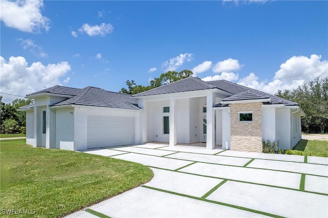 192 Herron Rd, North Fort Myers, FL 33903 - view of front of home featuring a tile roof, stucco siding, a front lawn, an attached garage, and driveway