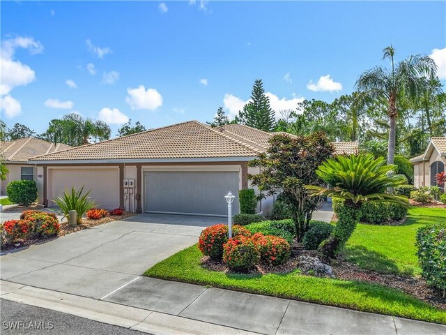 20698 Marathona Ct, North Fort Myers, FL 33917 - view of front of home featuring a tile roof, an attached garage, driveway, and stucco siding