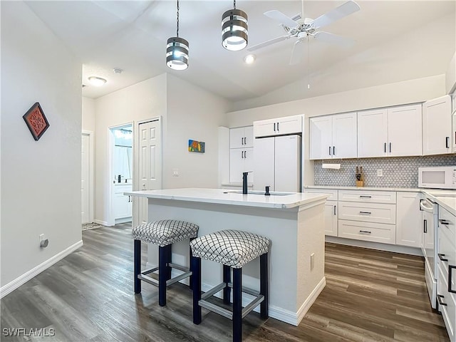 20698 Marathona Ct, North Fort Myers, FL 33917 - kitchen featuring white appliances, ceiling fan, dark wood-style flooring, white cabinets, and lofted ceiling
