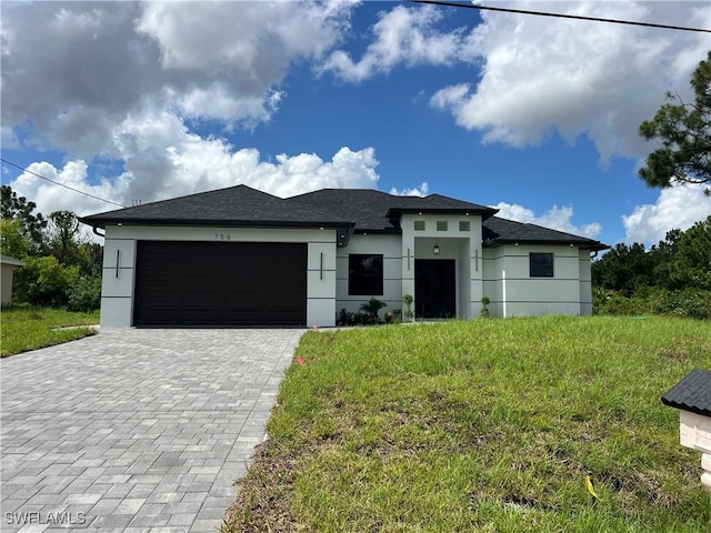 756 Chemstrand St E, Lehigh Acres, FL 33974 - prairie-style home featuring a garage, decorative driveway, and stucco siding