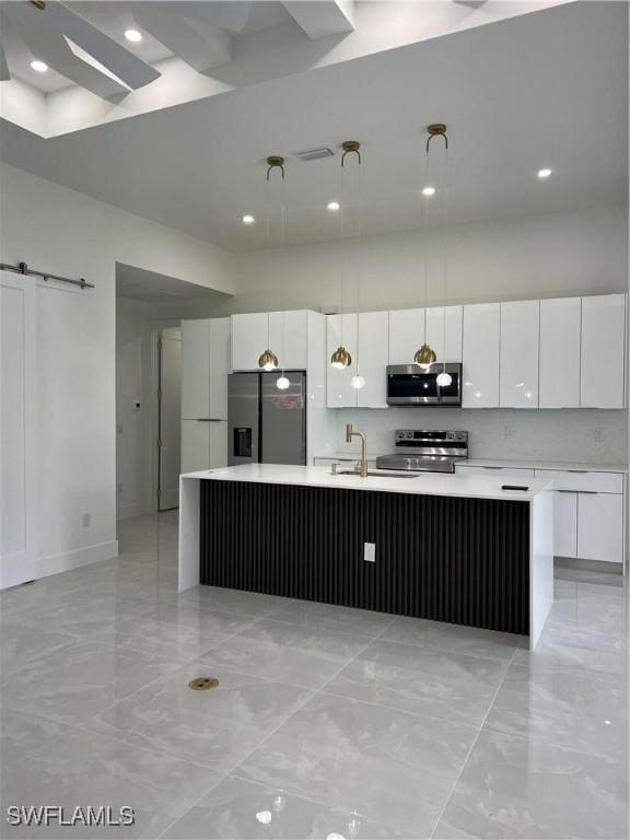 756 Chemstrand St E, Lehigh Acres, FL 33974 - kitchen with stainless steel appliances, white cabinetry, light marble finish floors, light countertops, and a large island