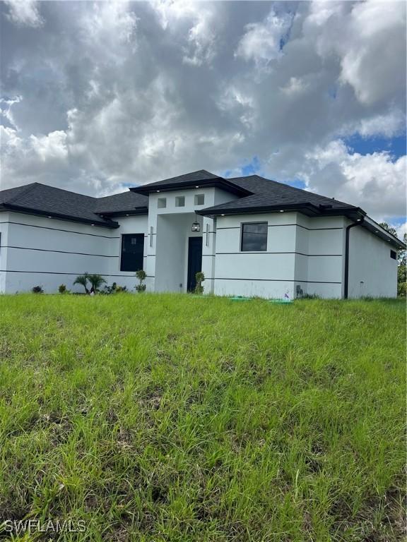 756 Chemstrand St E, Lehigh Acres, FL 33974 - view of front of home featuring stucco siding and a shingled roof