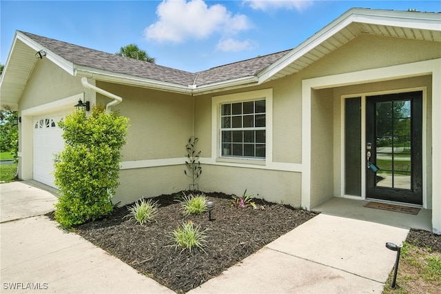 2711 4th St NW, Naples, FL 34120 - view of exterior entry with a garage, stucco siding, driveway, and a shingled roof