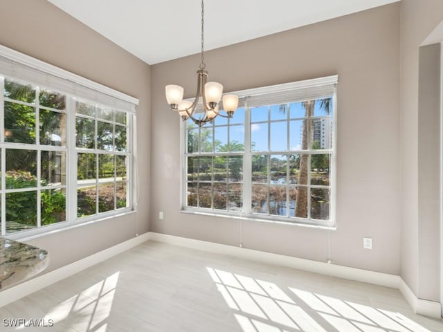 26690 Egrets Landing Dr Unit 101, Bonita Springs, FL 34134 - unfurnished dining area featuring a chandelier and plenty of natural light