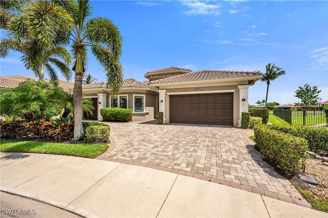 3910 Glacier Ct, Naples, FL 34119 - mediterranean / spanish-style house with a garage, decorative driveway, a tiled roof, and stucco siding