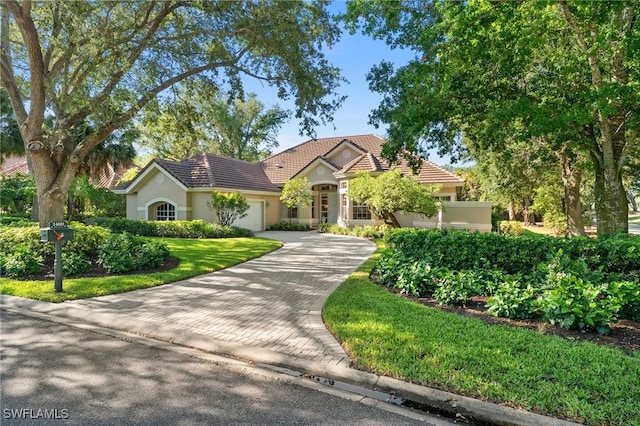 24881 Pennyroyal Dr, Bonita Springs, FL 34134 - single story home with an attached garage, decorative driveway, a tiled roof, and stucco siding