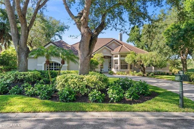 24881 Pennyroyal Dr, Bonita Springs, FL 34134 - view of front of property featuring a tiled roof, a chimney, and stucco siding