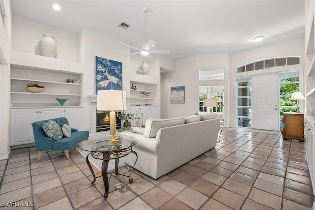 24881 Pennyroyal Dr, Bonita Springs, FL 34134 - living room with built in features, healthy amount of natural light, a glass covered fireplace, ceiling fan, and recessed lighting