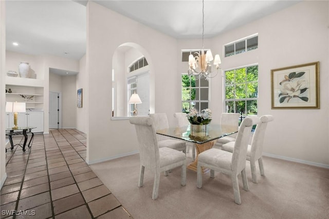 24881 Pennyroyal Dr, Bonita Springs, FL 34134 - carpeted dining room with a chandelier, arched walkways, built in shelves, recessed lighting, and tile patterned flooring