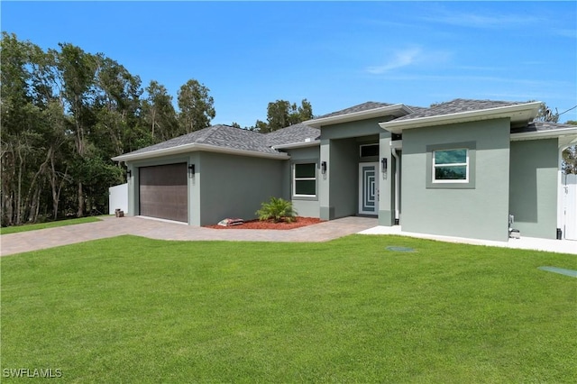 4205 Nora Ave S, Lehigh Acres, FL 33976 - prairie-style house with stucco siding, a front lawn, driveway, and an attached garage