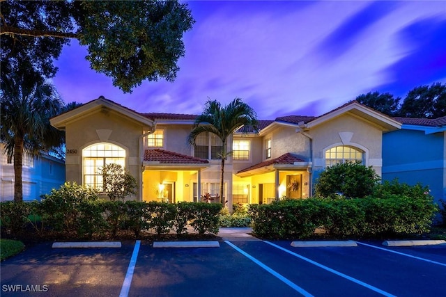 2450 Old Groves Rd Unit 201, Naples, FL 34109 - view of front of property with stucco siding, uncovered parking, and a tiled roof