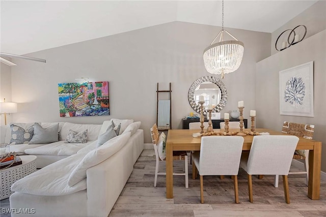 2450 Old Groves Rd Unit 201, Naples, FL 34109 - dining room featuring a chandelier, vaulted ceiling, and wood finished floors