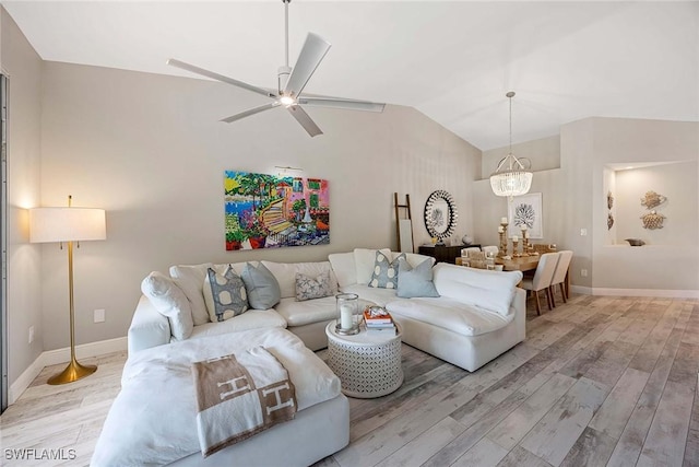 2450 Old Groves Rd Unit 201, Naples, FL 34109 - living room featuring lofted ceiling, light wood-style flooring, a ceiling fan, and a chandelier
