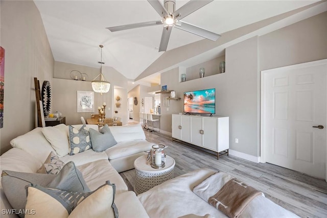 2450 Old Groves Rd Unit 201, Naples, FL 34109 - living room with wood finished floors, ceiling fan, vaulted ceiling, and a chandelier
