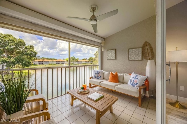 2450 Old Groves Rd Unit 201, Naples, FL 34109 - living area featuring a water view, a ceiling fan, vaulted ceiling, a textured wall, and light tile patterned flooring