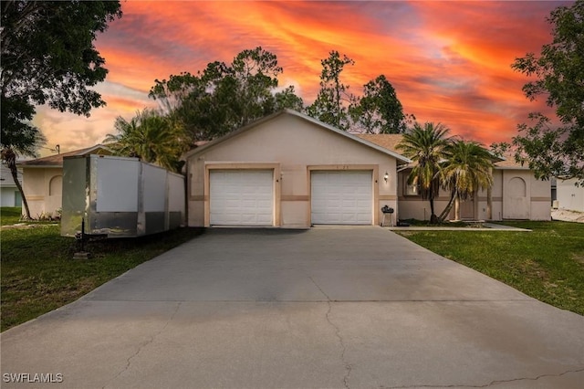 5421/5423 Centennial Blvd, Lehigh Acres, FL 33971 - view of front facade with stucco siding, a yard, driveway, and an attached garage