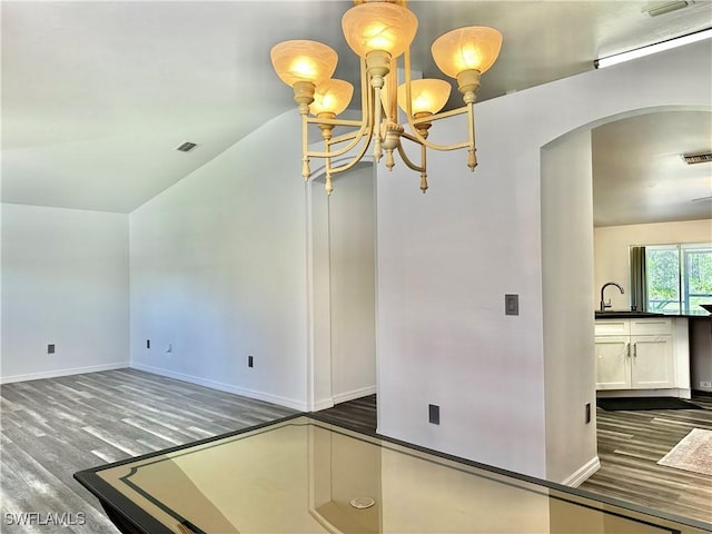 2675 70th Ave NE, Naples, FL 34120 - unfurnished room featuring arched walkways, wood finished floors, a chandelier, and lofted ceiling