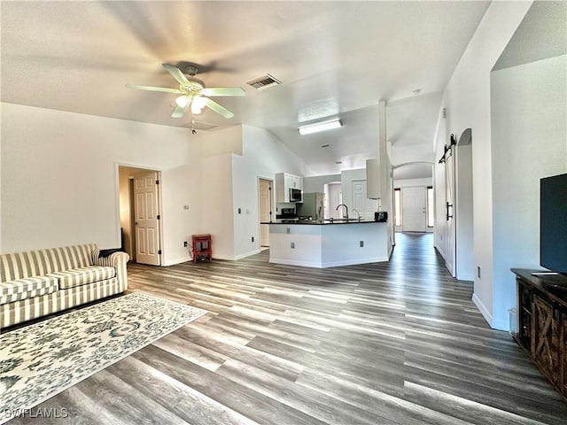 2675 70th Ave NE, Naples, FL 34120 - unfurnished living room with a barn door, a ceiling fan, wood finished floors, and high vaulted ceiling