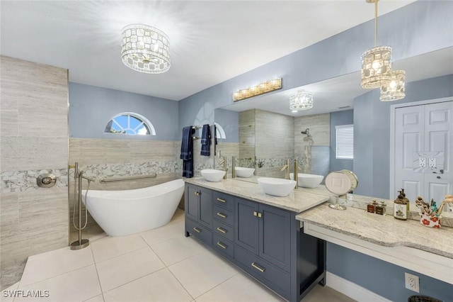 4404 SW 5th Ave, Cape Coral, FL 33914 - bathroom with tile walls, tile patterned floors, a chandelier, a soaking tub, and double vanity