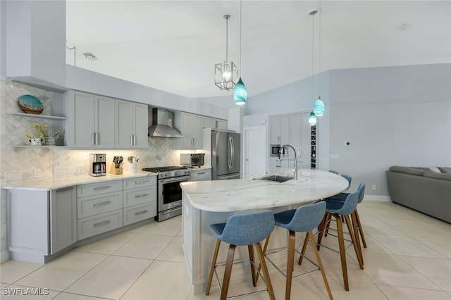 4404 SW 5th Ave, Cape Coral, FL 33914 - kitchen with appliances with stainless steel finishes, gray cabinetry, wall chimney exhaust hood, light tile patterned flooring, and tasteful backsplash