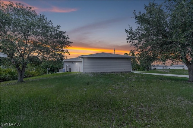 2818 66th St W, Lehigh Acres, FL 33971 - property exterior at dusk with a lawn