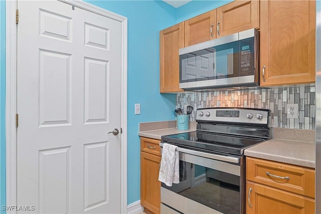 9015 Colby Dr Unit 2010, Fort Myers, FL 33919 - kitchen with appliances with stainless steel finishes, tasteful backsplash, and light countertops