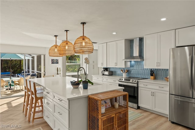 486 Lake Murex Cir, Sanibel, FL 33957 - kitchen with stainless steel appliances, wall chimney exhaust hood, light countertops, white cabinets, and recessed lighting