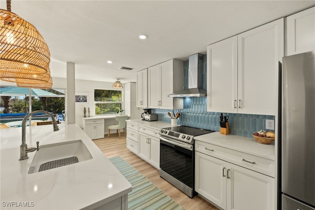 486 Lake Murex Cir, Sanibel, FL 33957 - kitchen with appliances with stainless steel finishes, wall chimney exhaust hood, light wood-style floors, backsplash, and white cabinets
