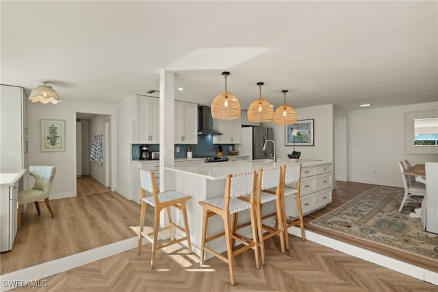 486 Lake Murex Cir, Sanibel, FL 33957 - kitchen with freestanding refrigerator, wall chimney range hood, light countertops, a kitchen bar, and white cabinets